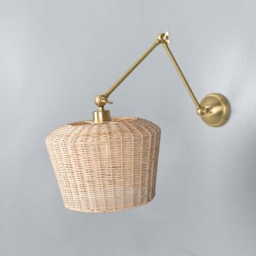 rattan wall light with adjustable satin brass arm