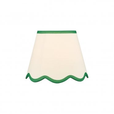 A neutral scalloped edge table lamp shade with green accent edging